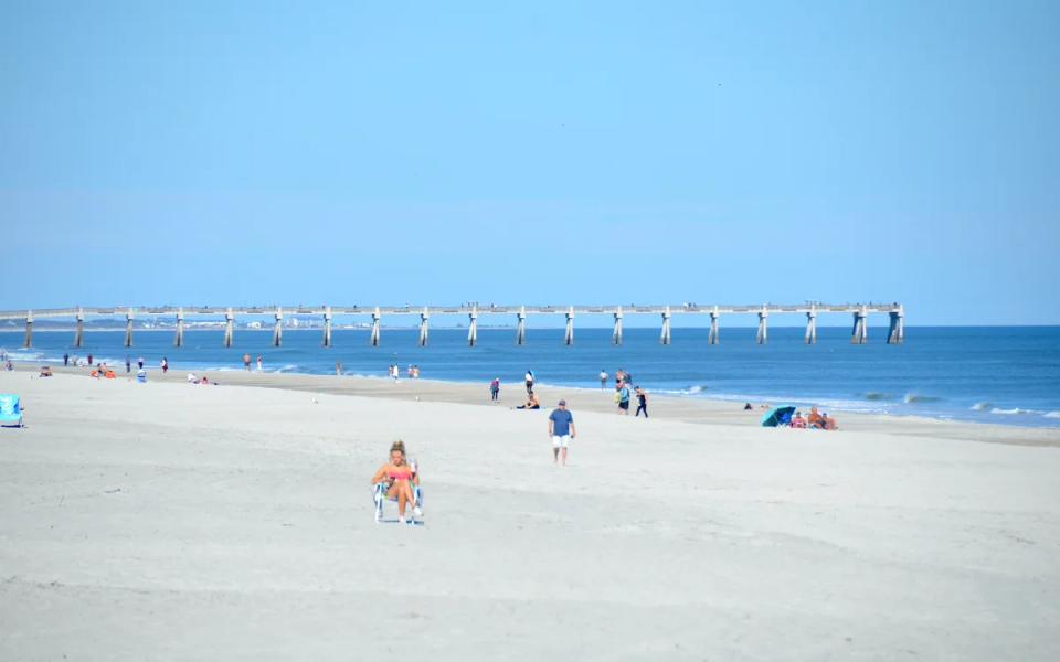 The fishing pier at Jacksonville Beach extending over the sea.