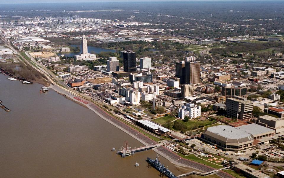 An aerial view of Baton Rouge beside the Mississippi River, with the state capitol visible.