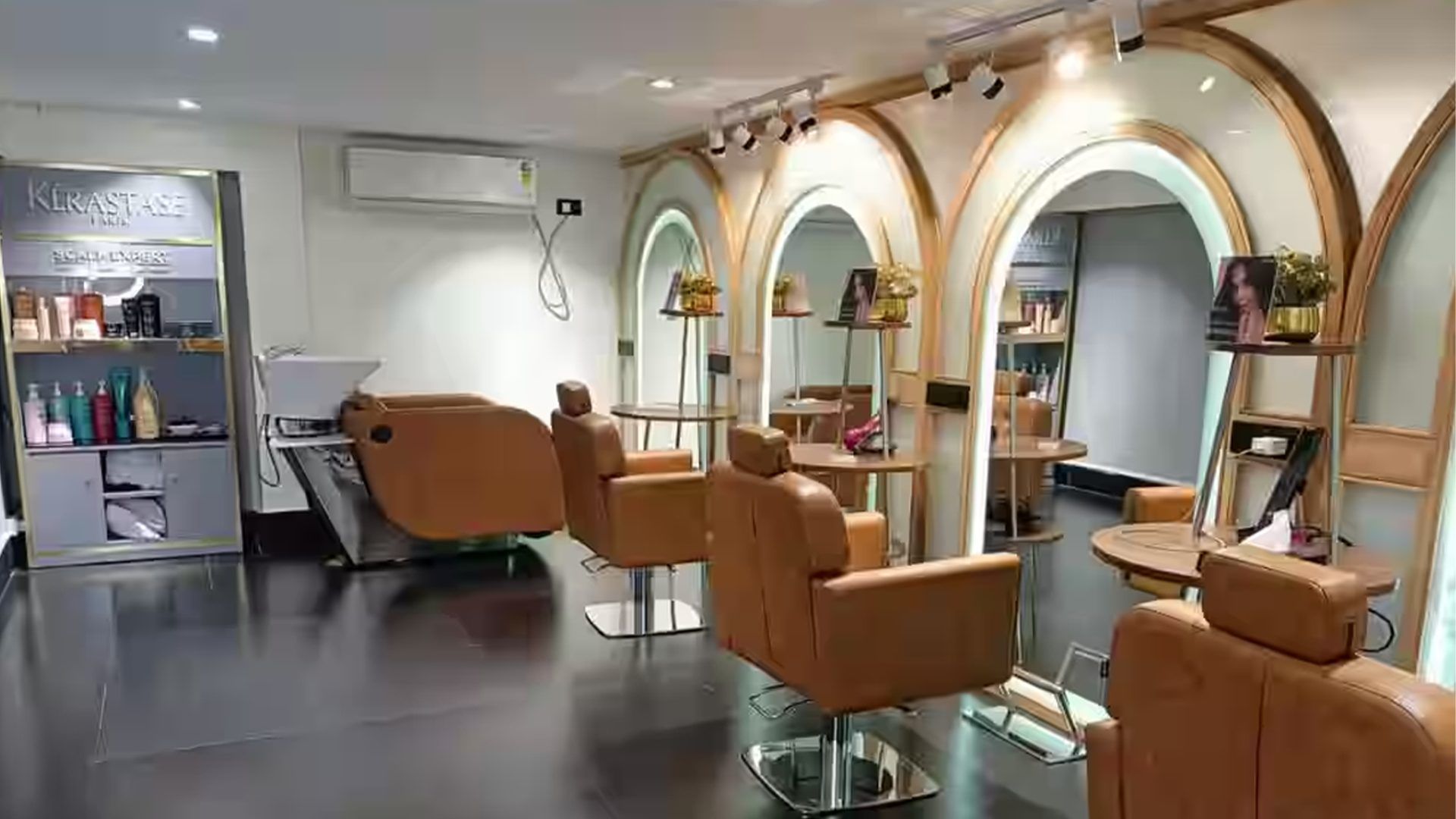 The Monsoon Salon floor in Kolkata — styling chairs beneath warm arched alcoves