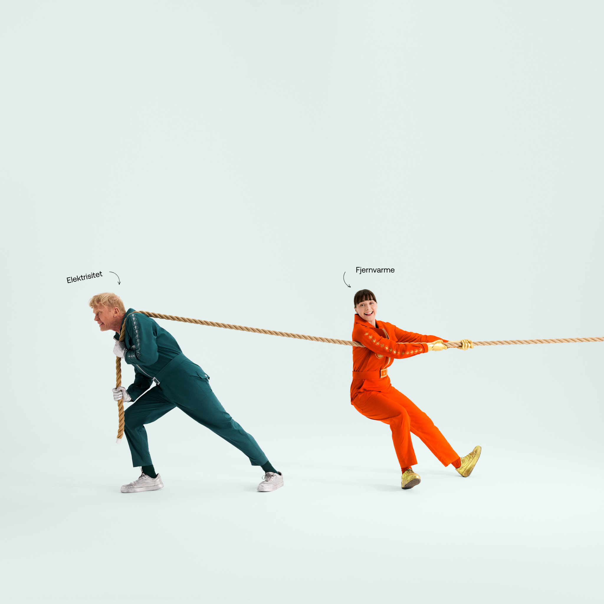 a man and a woman are pulling a rope and the woman is wearing orange