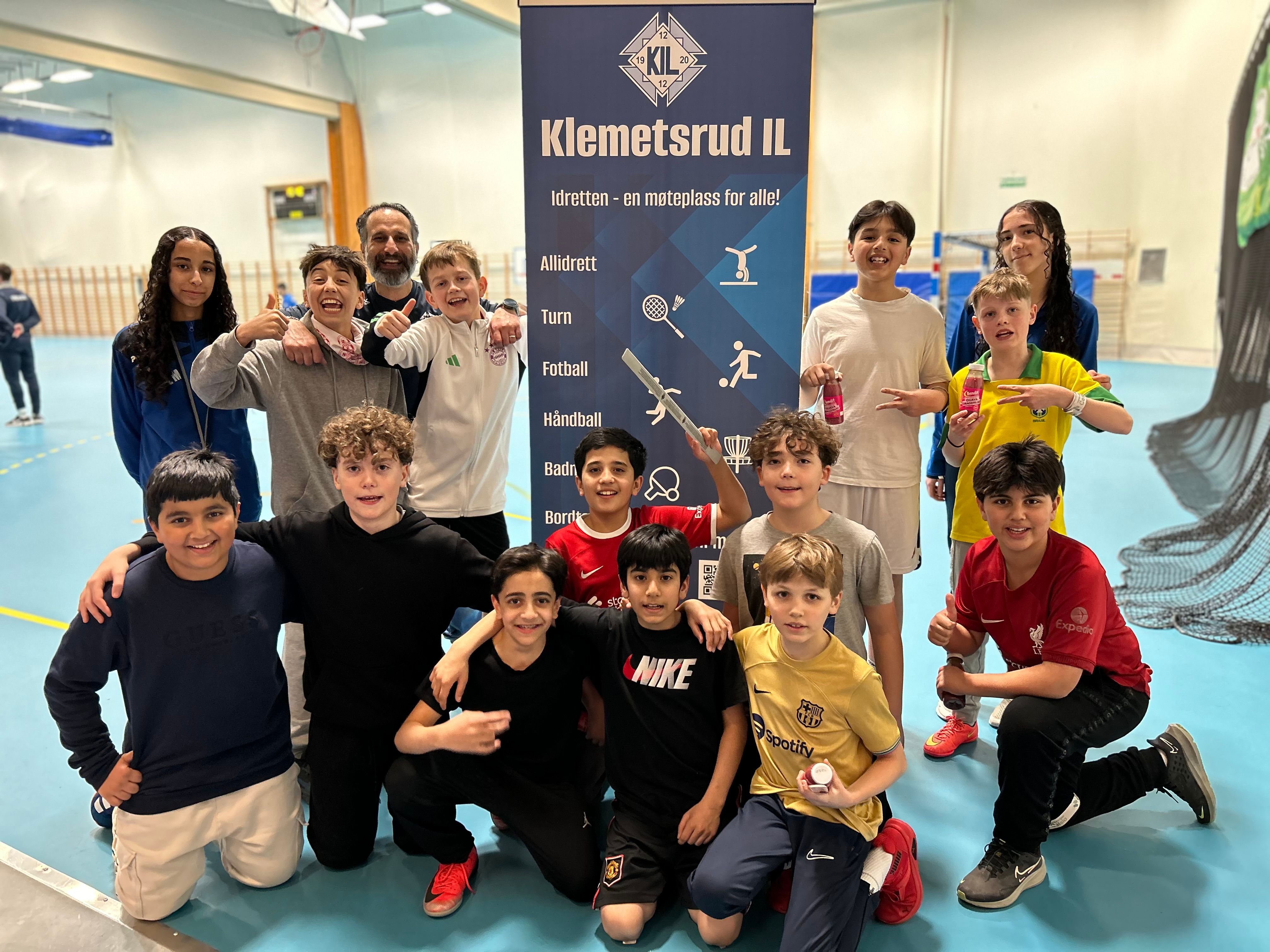 en gruppe unge mennesker poserer for et bilde foran et banner.