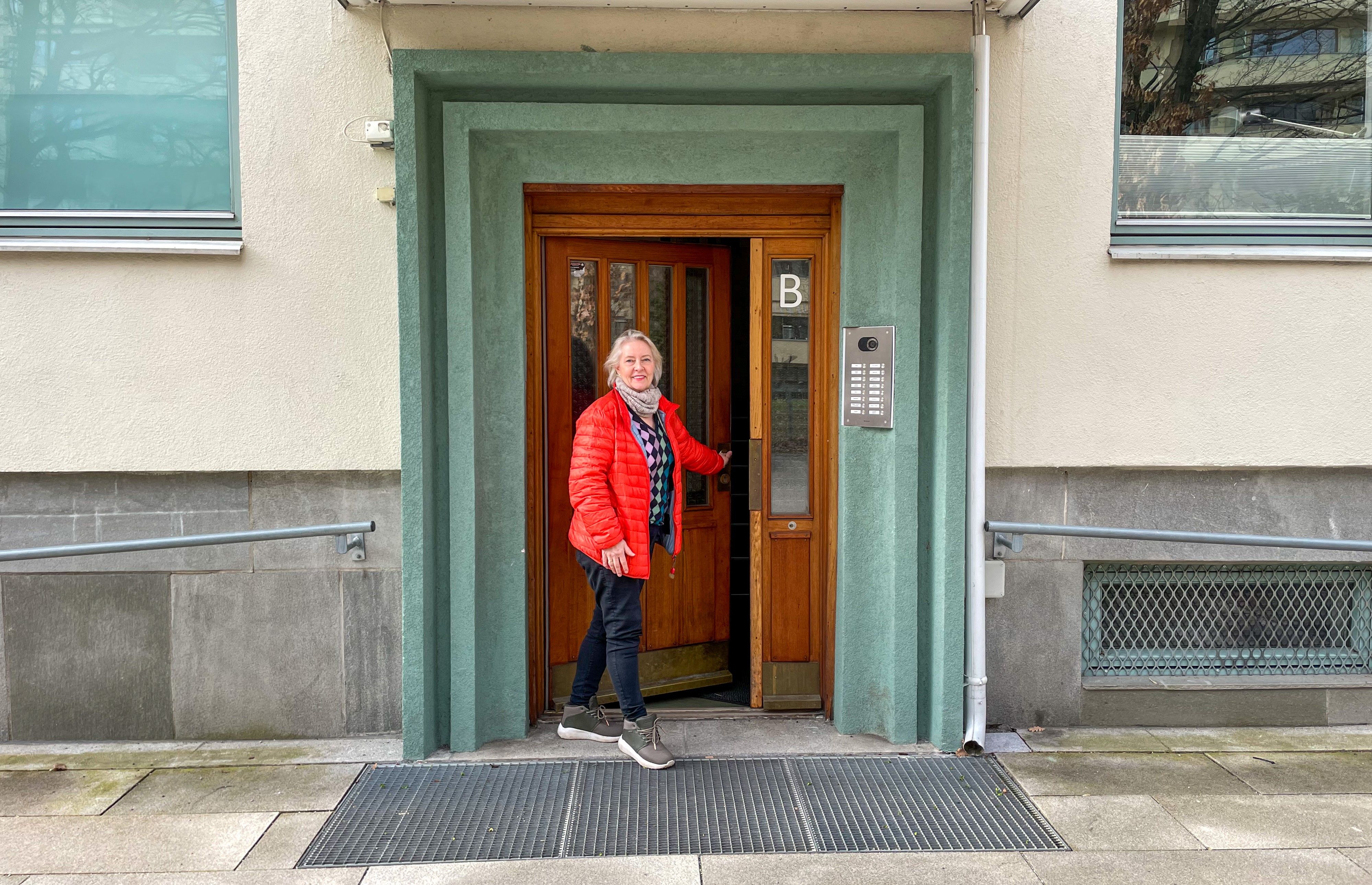 En kvinne står i døråpningen til sameiet der hun er styreleder.