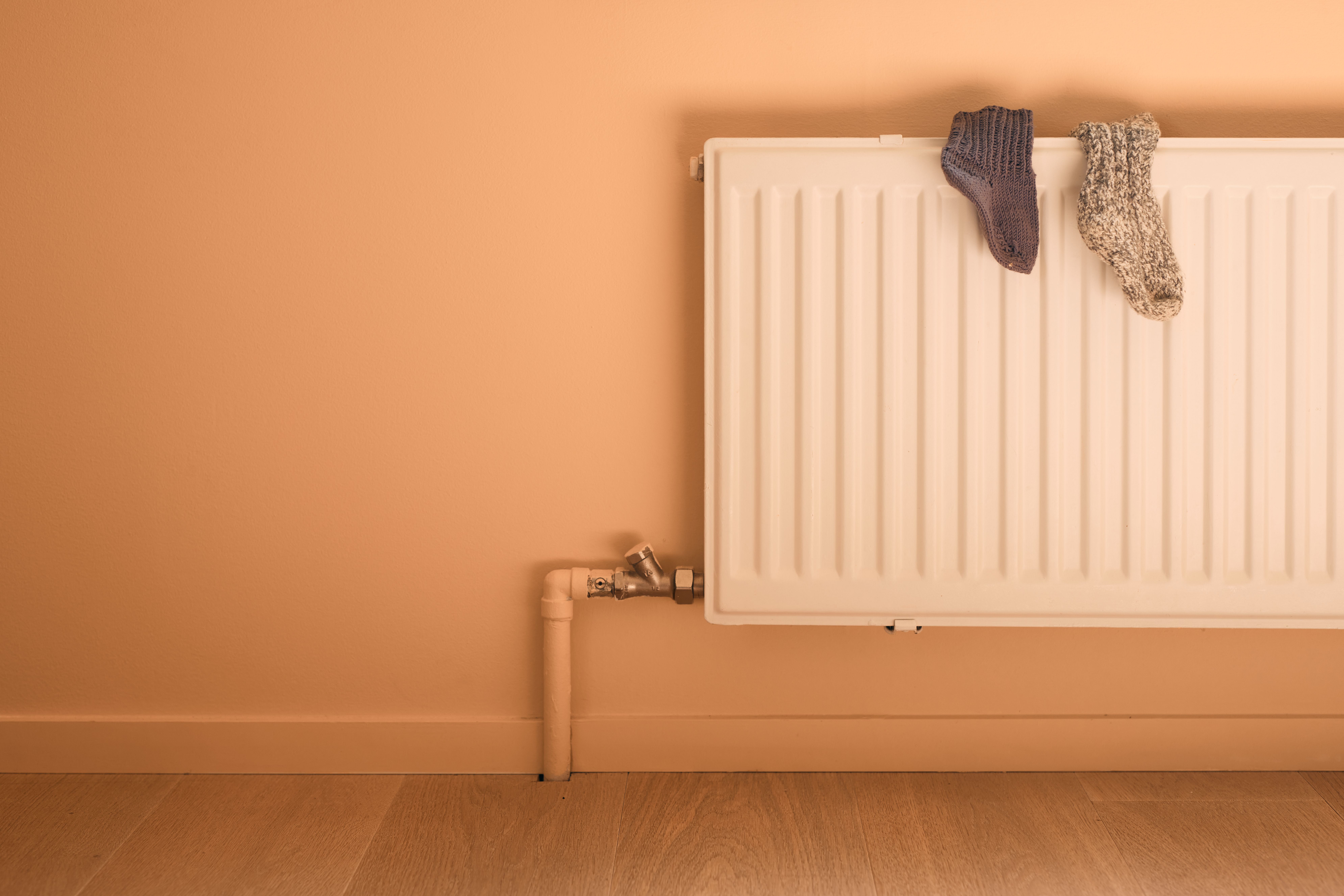 To sokker som henger til tørk over en radiator.