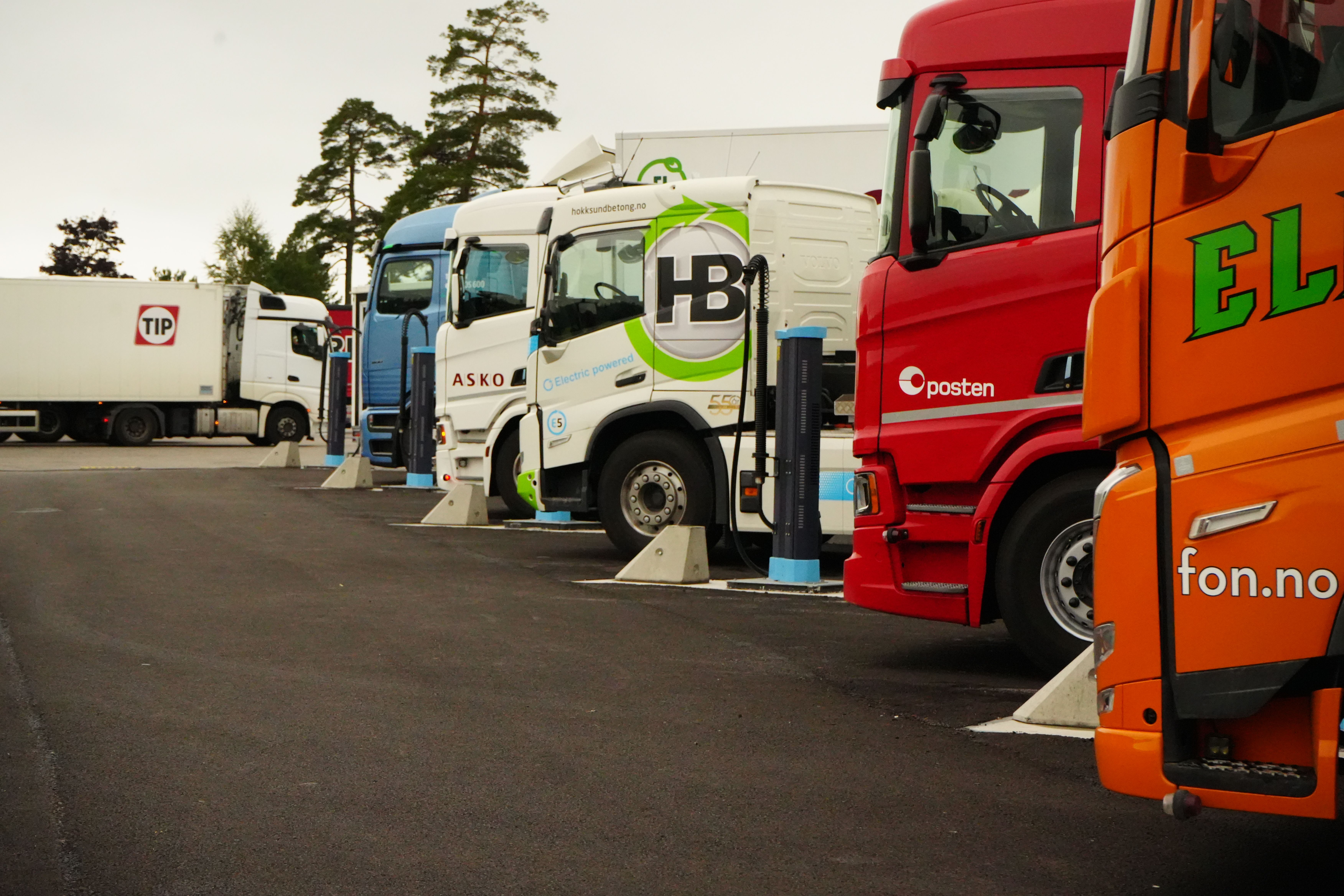 a row of trucks are parked in a parking lot .