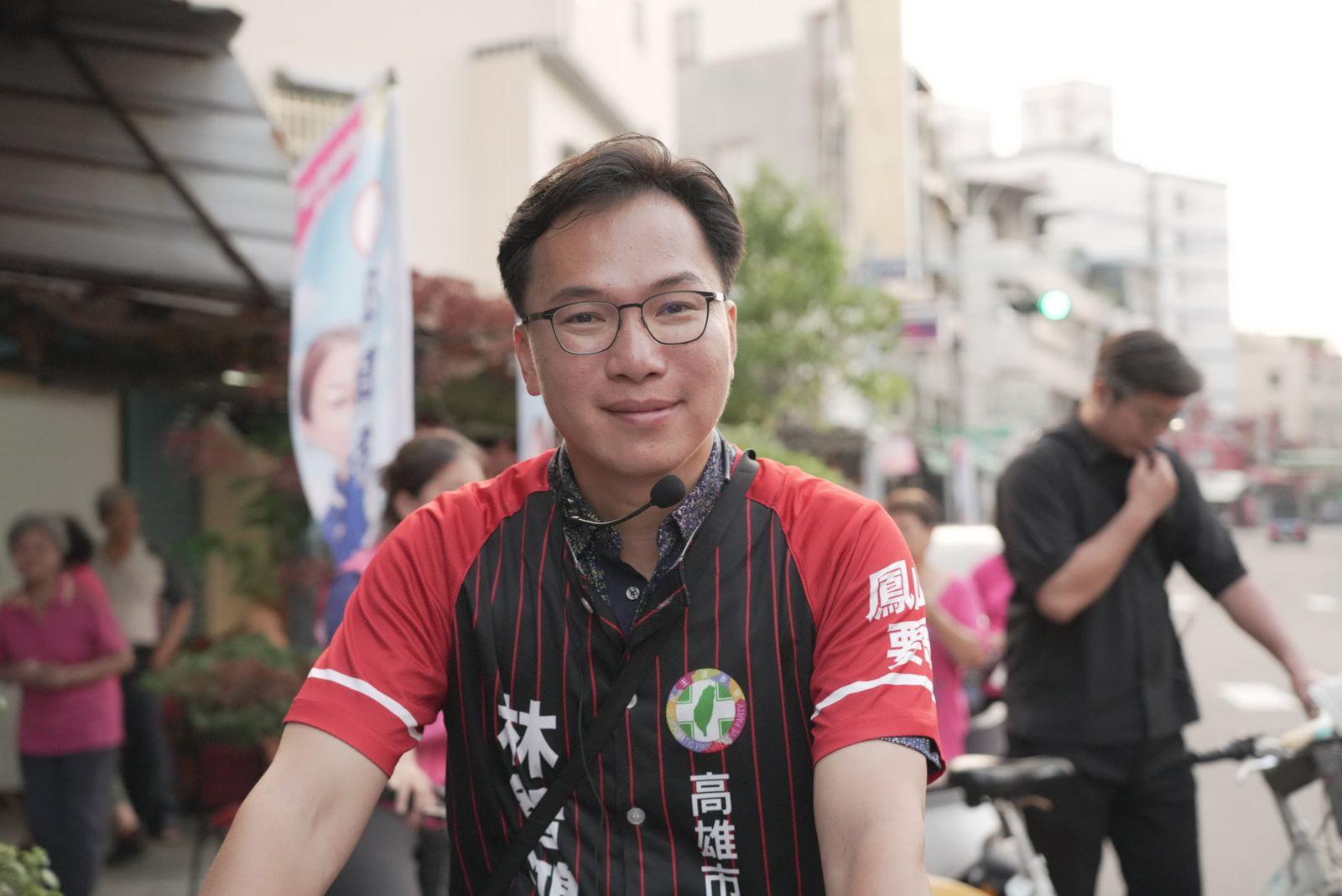 林智鴻穿著紅黑直條紋競選車衣,坐在腳踏車上,背景是鳳山街道