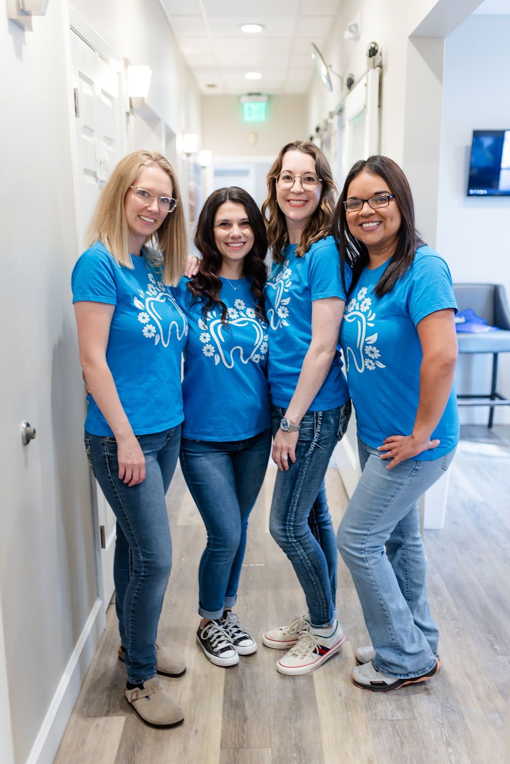 a group of women wearing blue shirts with a tooth on them