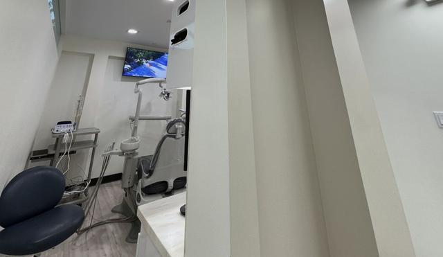 a dental office with a dental chair and a television on the wall .