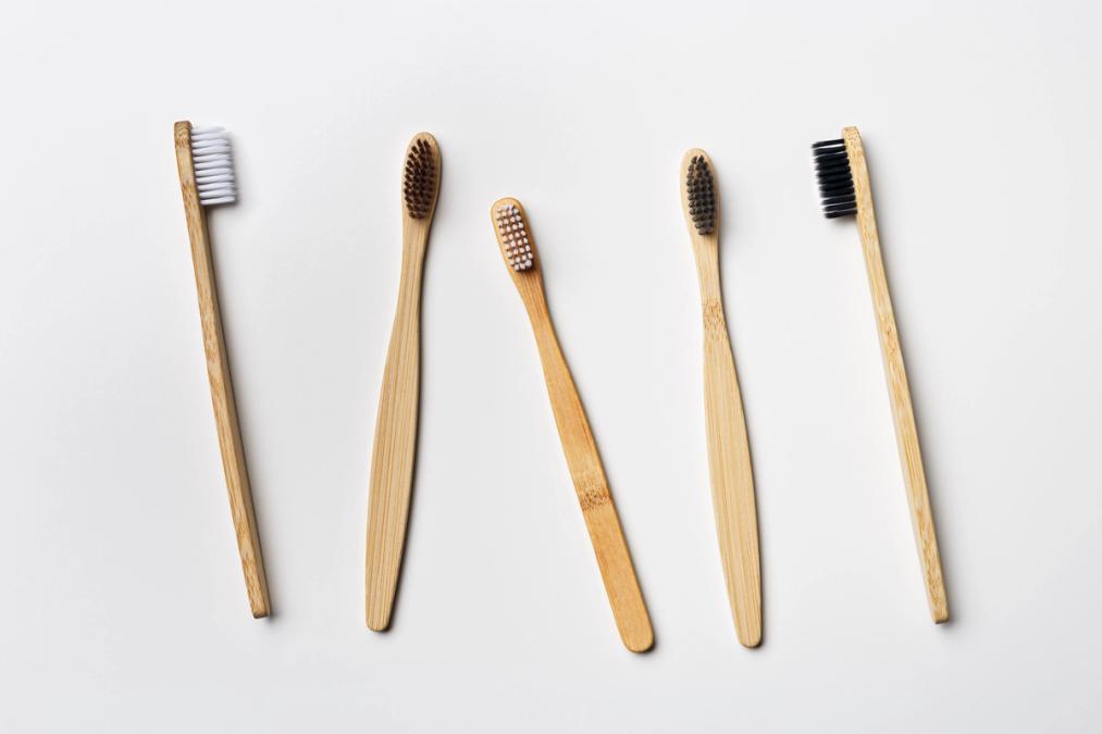a row of bamboo toothbrushes on a white background .