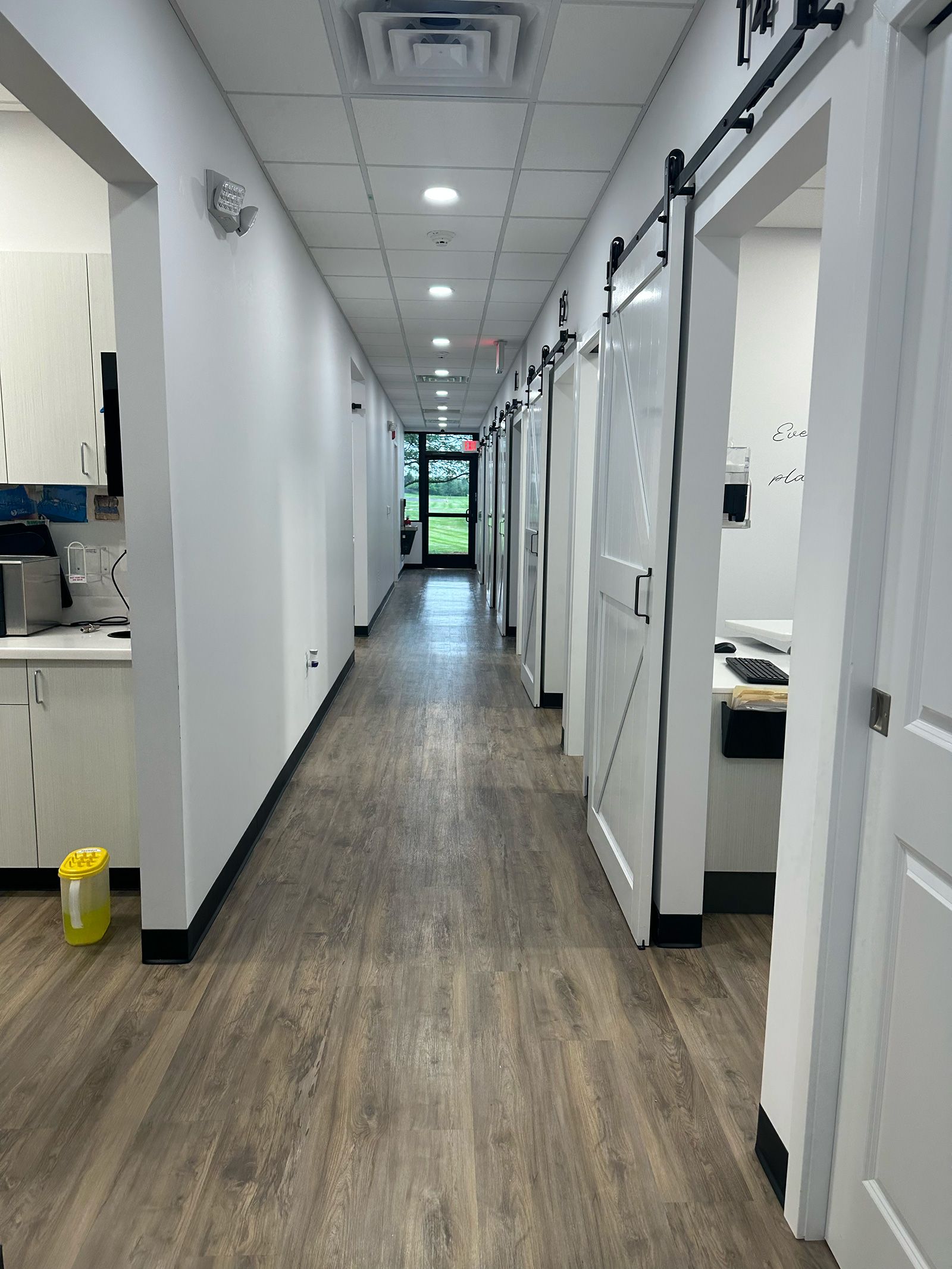 a long hallway in a dental office with sliding barn doors