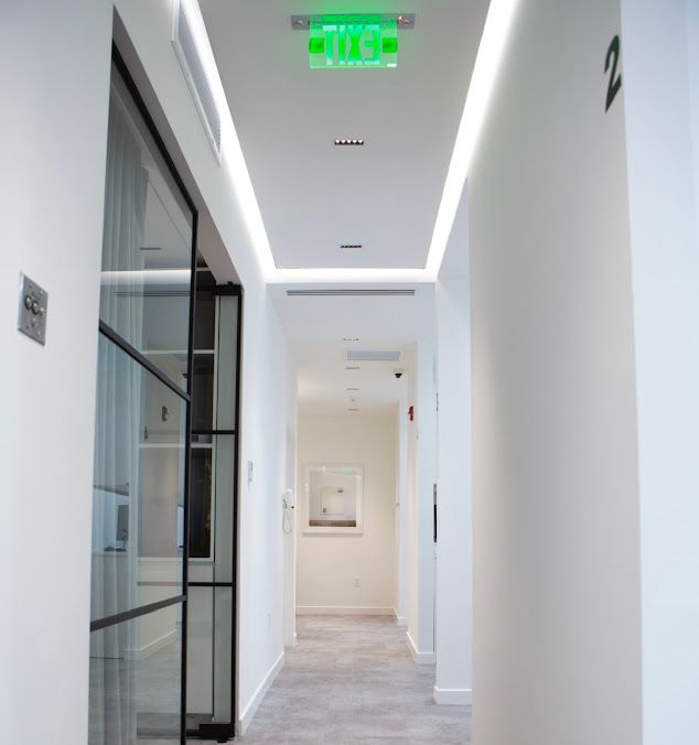 a long hallway with a green exit sign on the ceiling .
