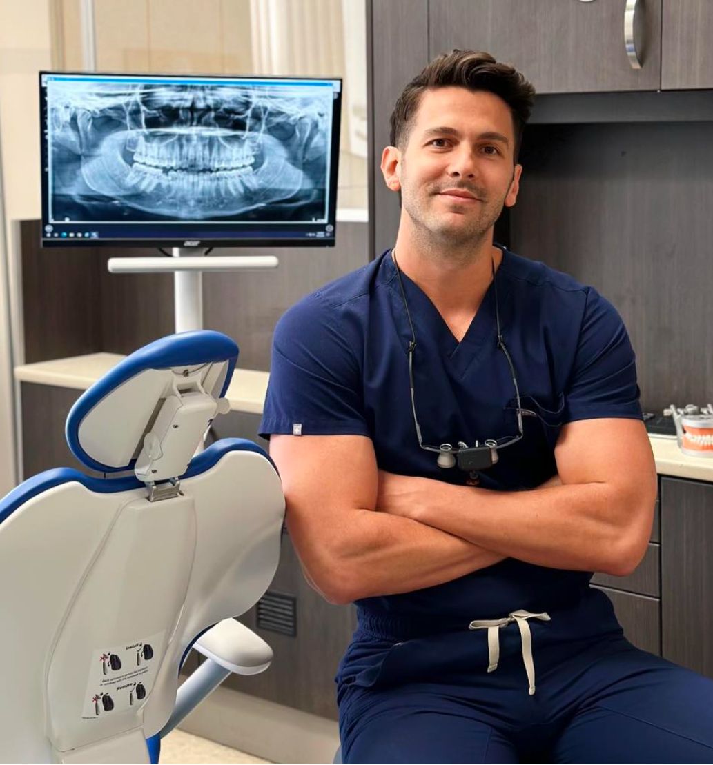 a man is sitting in a dental chair with his arms crossed