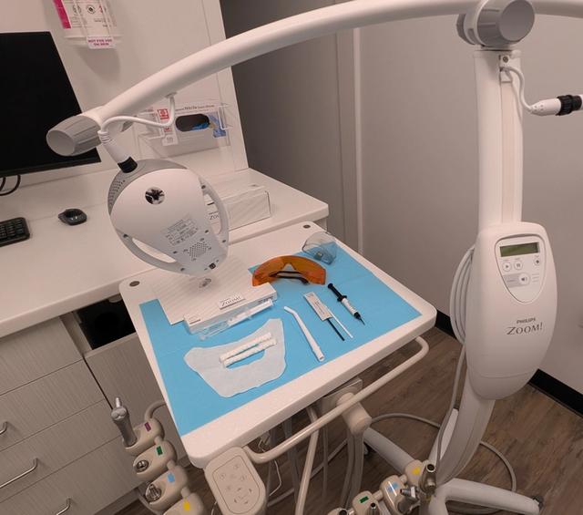 a dental office with a dental chair and a whitening machine .