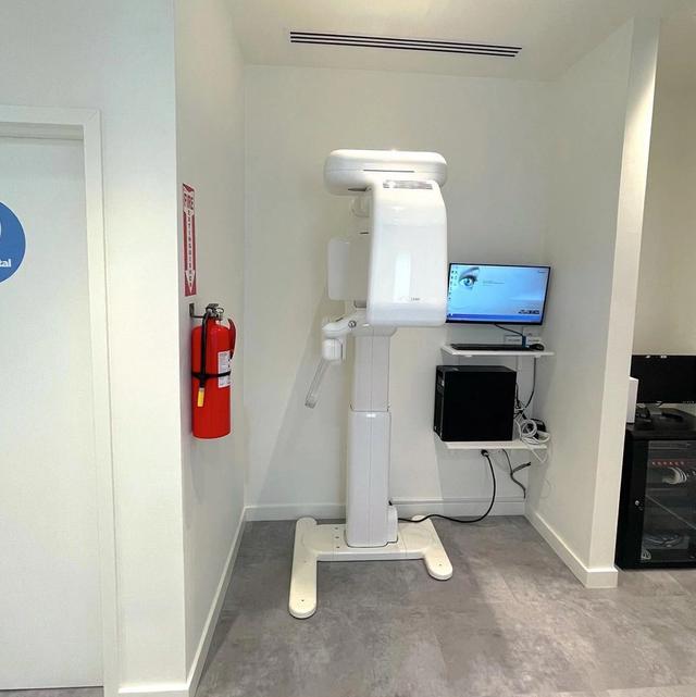 an x-ray machine is sitting in a room next to a fire extinguisher .