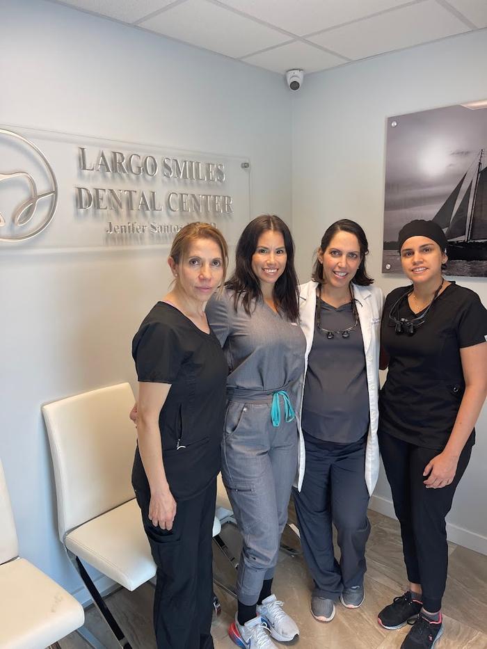 a group of female dental assistants pose in front of largo smiles dental center