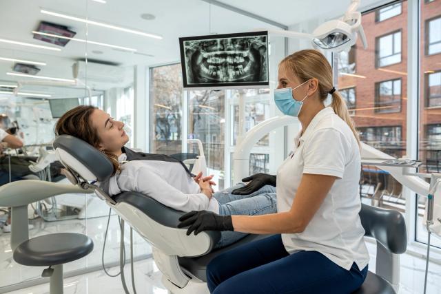 a dental chair with a monitor and dental instruments in a dental office .