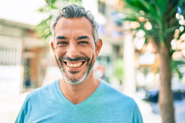 a man with a beard is smiling and looking at the camera .