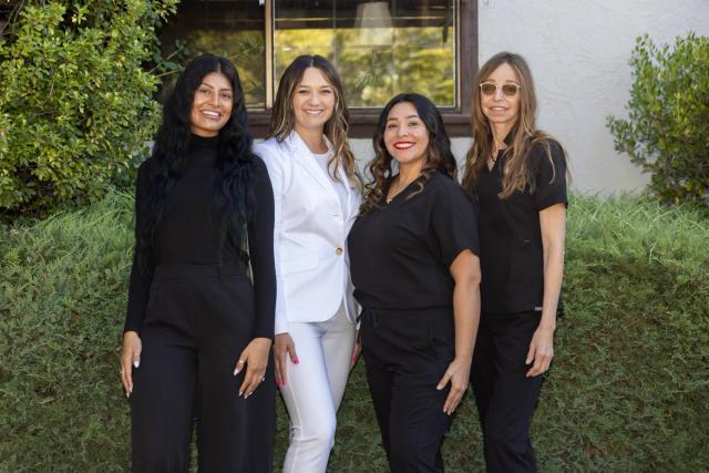 a group of women are posing for a picture in front of a building .