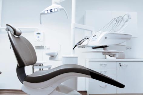 a dental office with a dental chair and dental equipment .