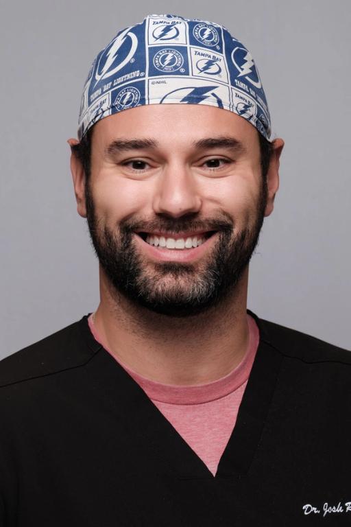 a man wearing a tampa bay hat smiles for the camera