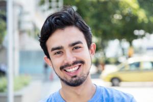 un hombre joven con barba está sonriendo para la cámara.