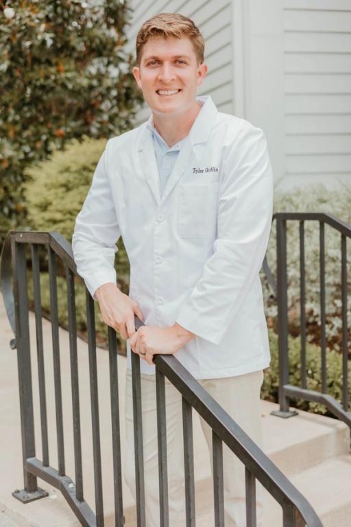 a man in a white coat with the name tyler on it