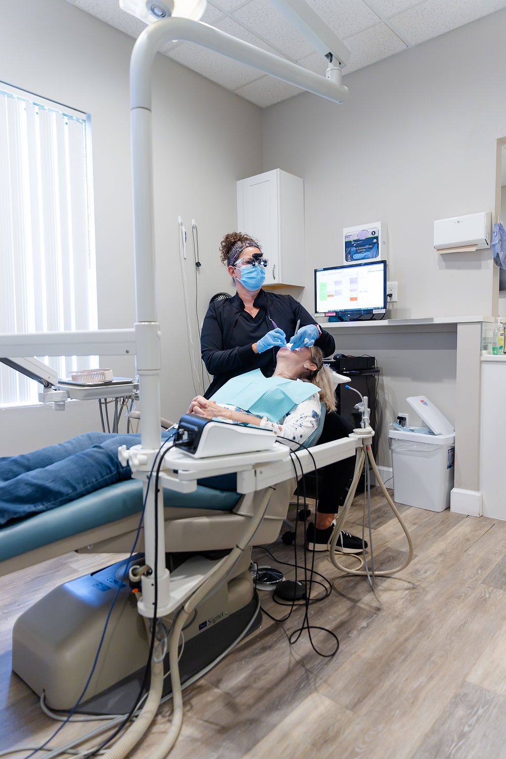 a woman is getting her teeth examined by a dentist