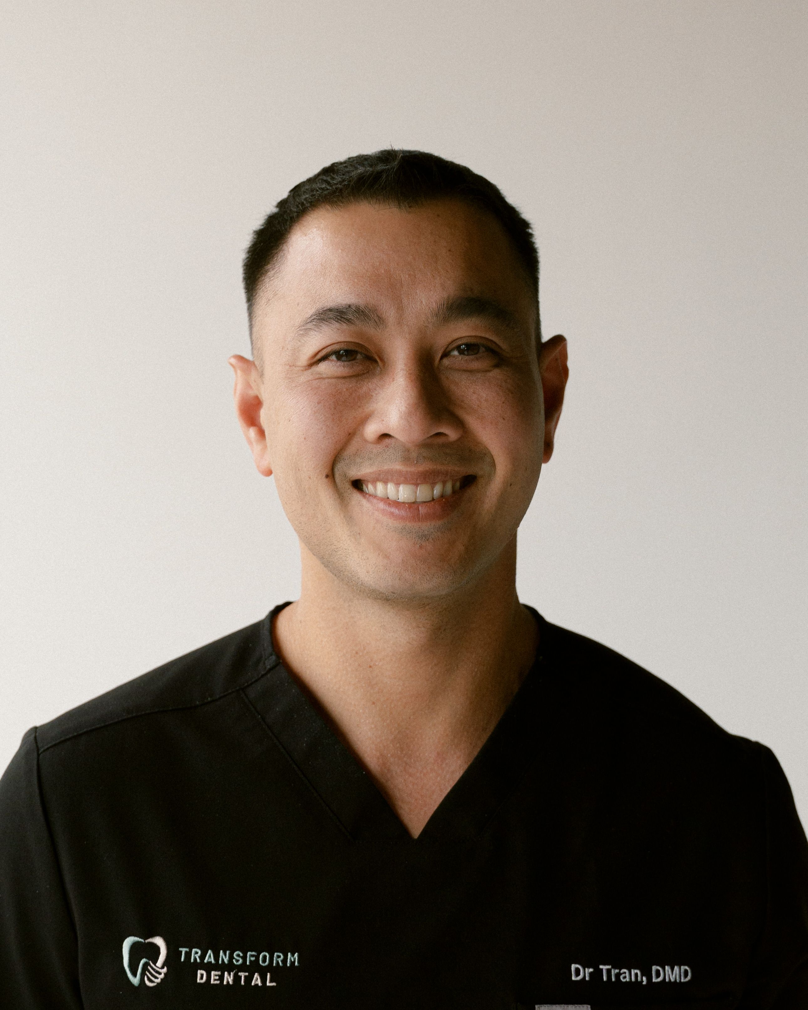 a man wearing a black shirt that says transform dental
