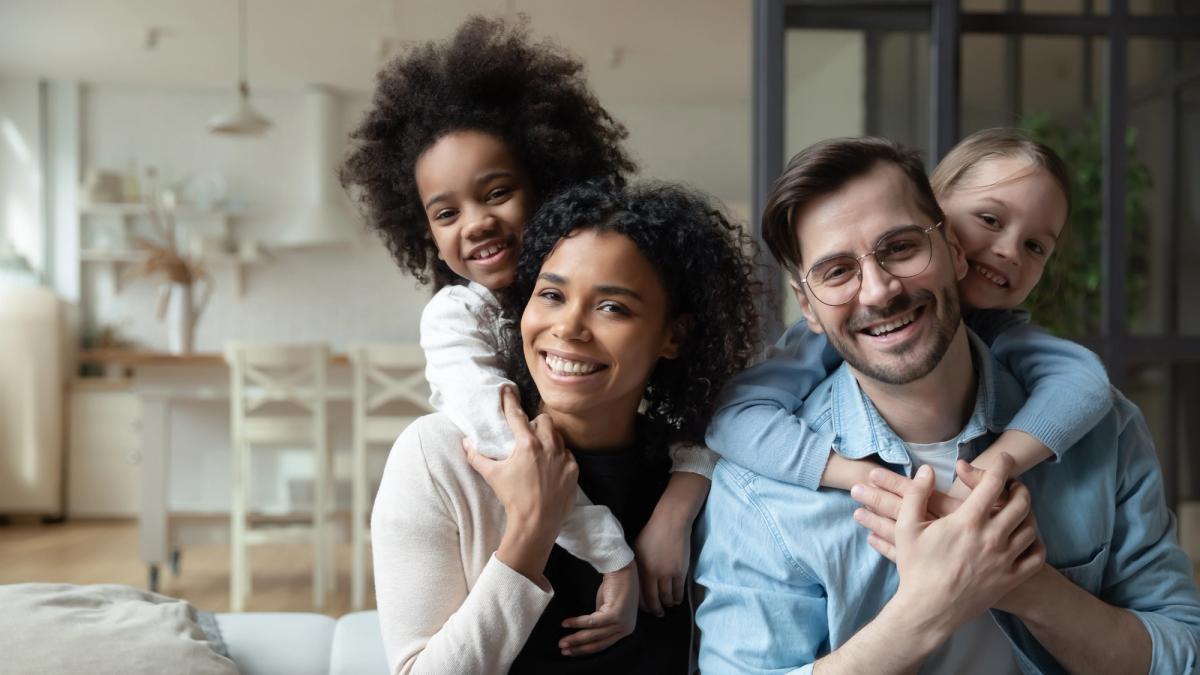 a family is posing for a picture while sitting on a couch .