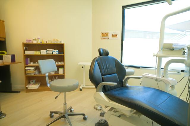 a dental office with a dental chair and a stool .