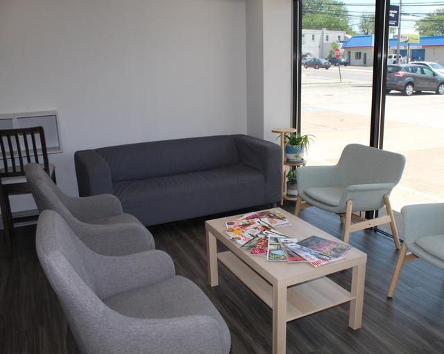 a waiting room with a couch , chairs , and a coffee table .