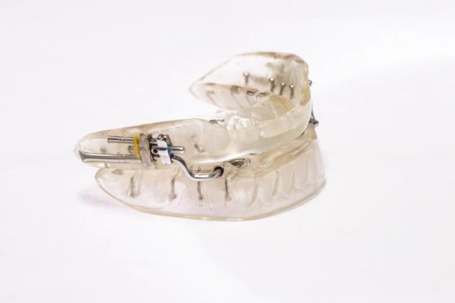 a clear mouth guard is sitting on a white surface .