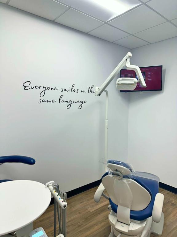 a dental office with a sign on the wall that says everyone smiles in the same language