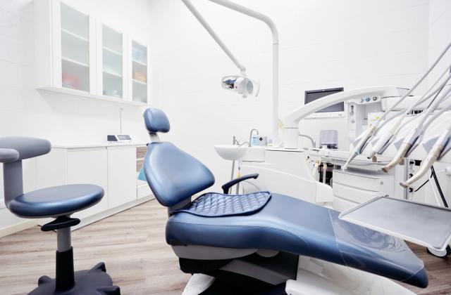 an empty dental office with a dental chair and dental equipment .