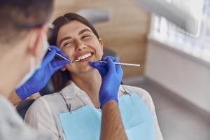 Smiling woman in a dentist's chair during an examination.
