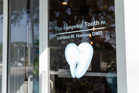 the front door of a dental office with a tooth in the window .