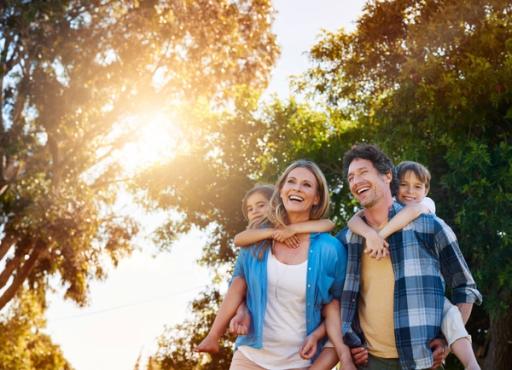 a family is walking through a park with trees in the background .