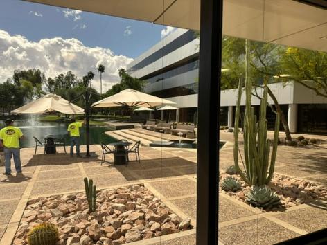 a view of a patio with umbrellas and cactus from a window .