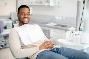 Smiling young man in a dental chair with a bib.