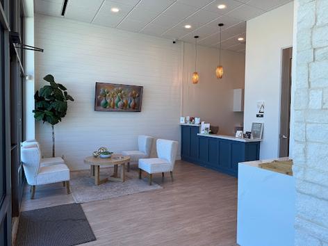 a waiting room with chairs , a table and a television .