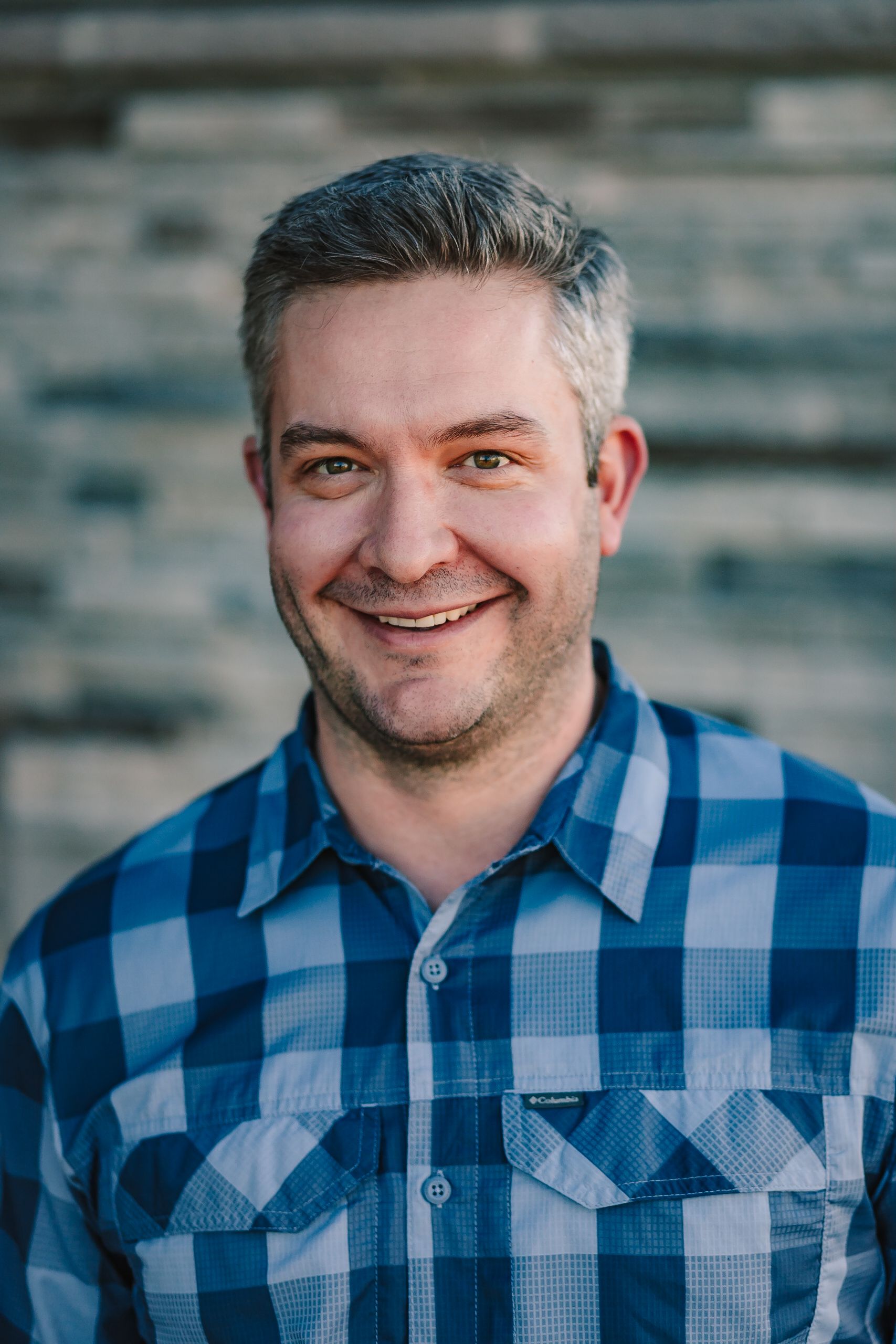 a man in a black scrub top is smiling for the camera .