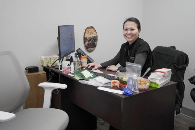 a woman is sitting at a desk in front of a computer .