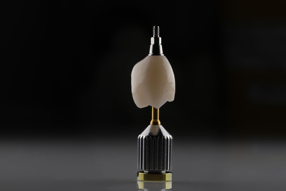 a dental implant is sitting on top of a drill bit on a table .