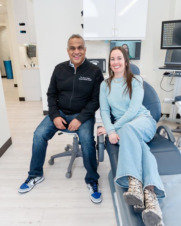 a man and a woman are sitting in a dental chair .
