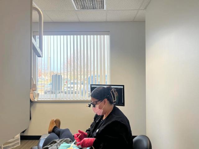 a dentist is working on a patient 's teeth in a dental office .