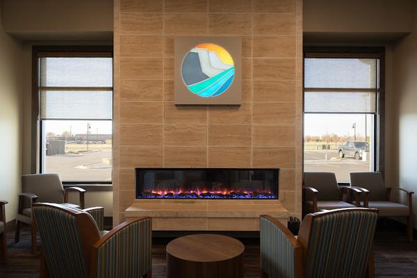 a living room with a fireplace , chairs and a table .