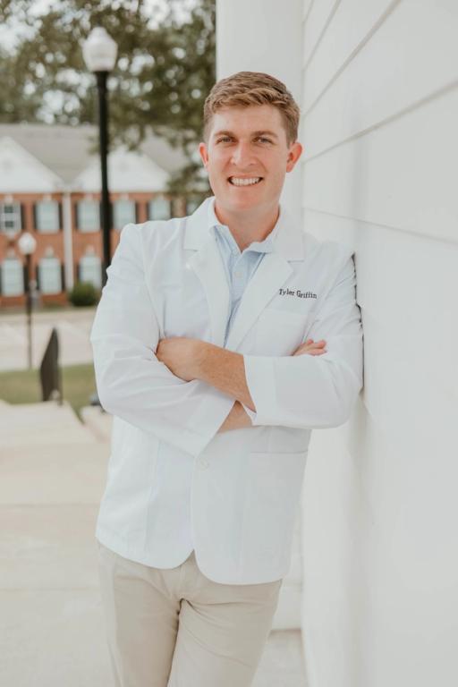 a man in a white lab coat with the name tyler on it