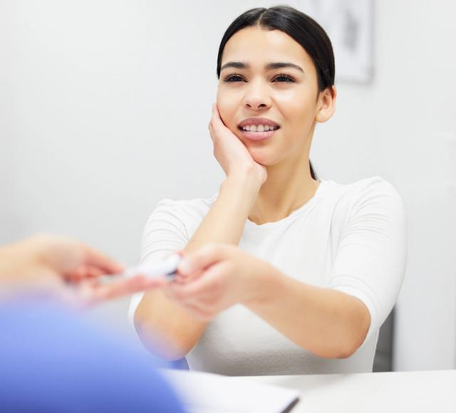 a woman is sitting at a table giving a business card to another woman .