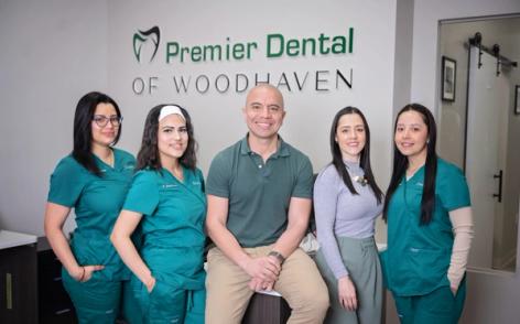 a group of dentists are posing for a picture in a dental office .