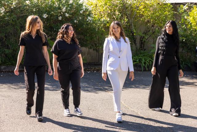 a group of women are walking down a street .