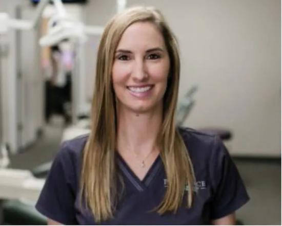 a woman in a dental office is smiling for the camera .